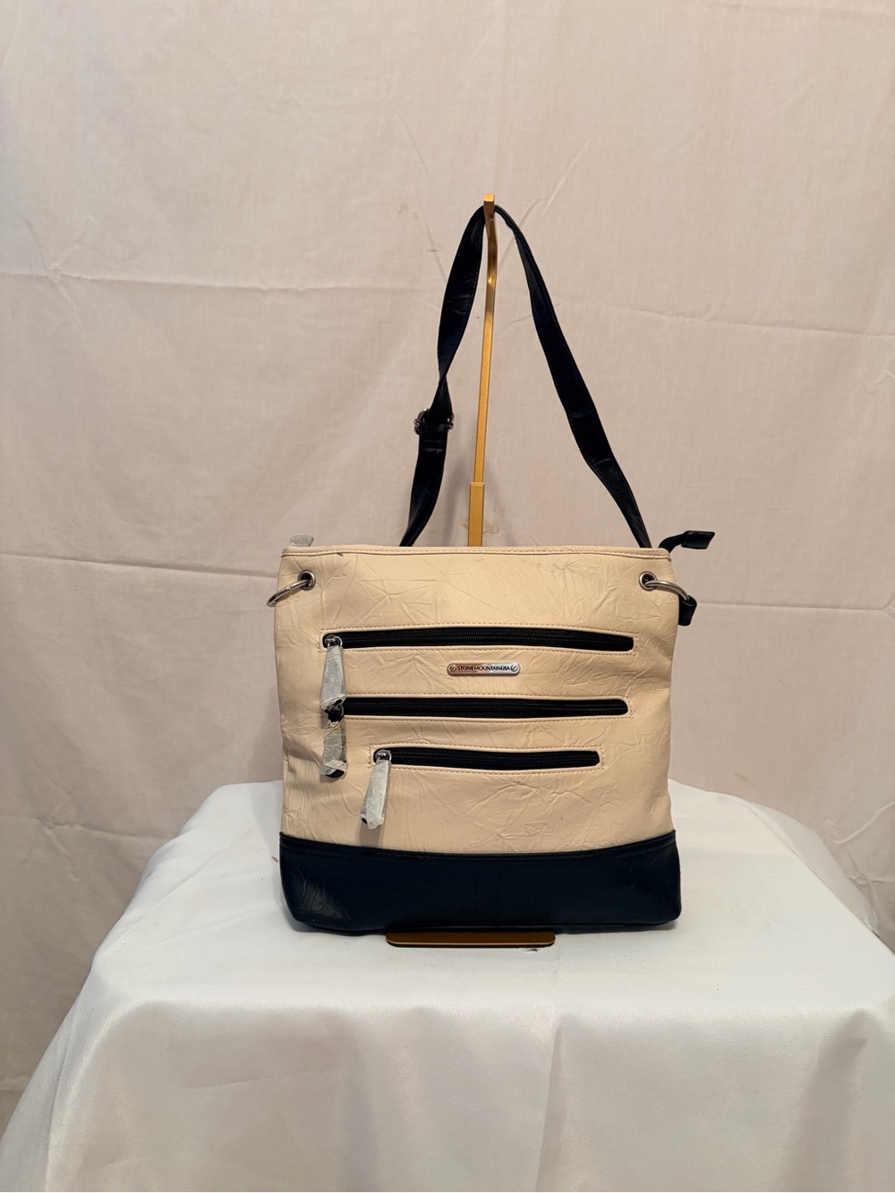 Stone Mountain two-tone leather cream & black leather accents, multiple pockets.